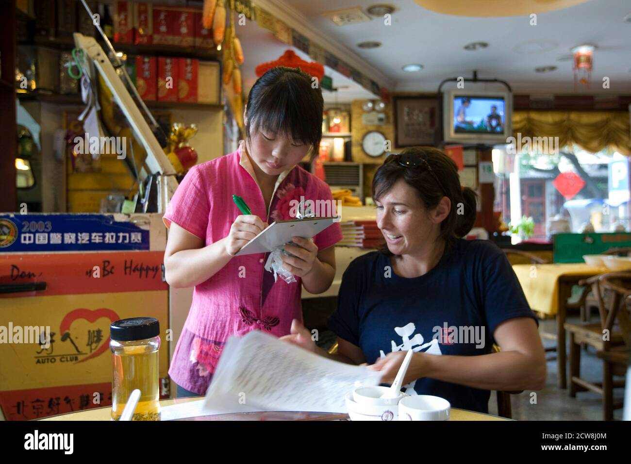 Pechino, Cina 18 settembre 2008: Il turista americano ottiene l'aiuto di mettere il suo ordine in un ristorante di quartiere a Pechino vicino alla Città Proibita nel cuore di Pechino. ©Bob Daemmrich Foto Stock