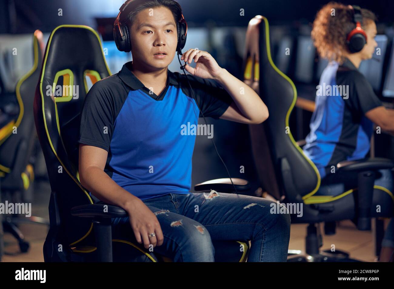 Errore. Ritratto di un ragazzo asiatico, un giocatore di cyber sport maschile con cuffie che guarda lo schermo del PC con il volto confuso mentre si gioca a videogiochi online. Partecipazione al torneo eSports Foto Stock
