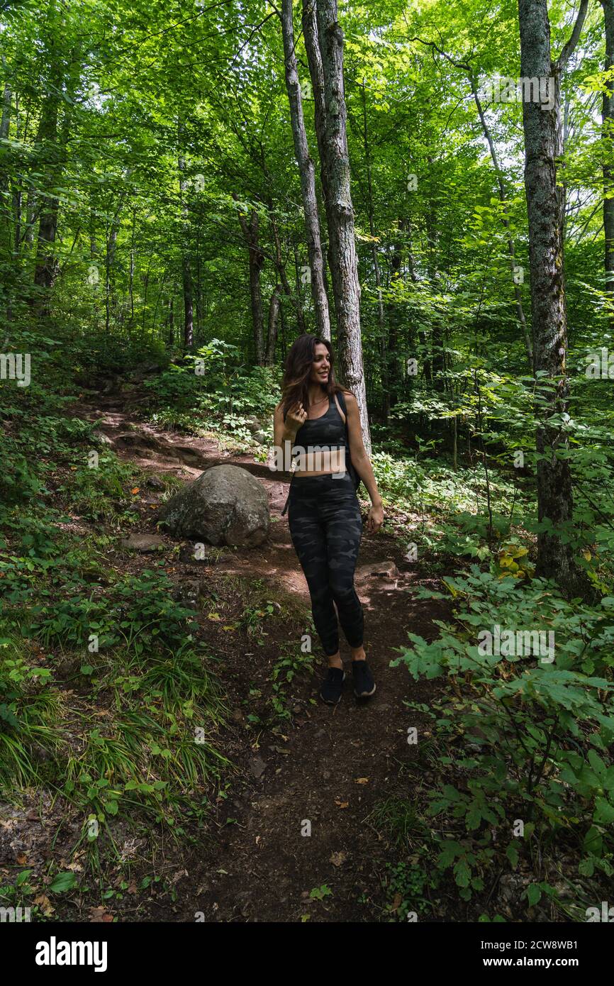 Una giovane donna che camminano su un sentiero nel Adirondacks Foto Stock