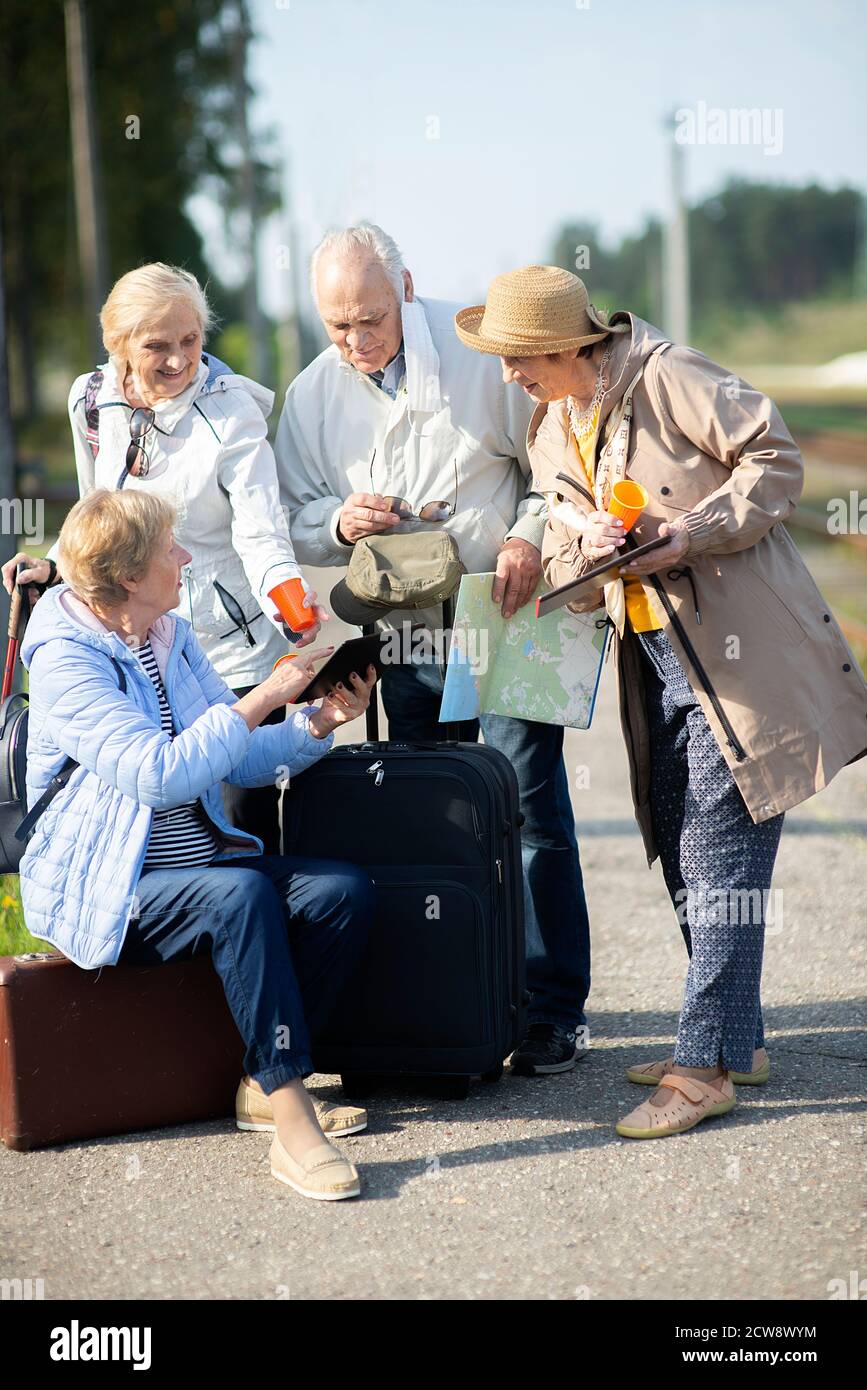 Gruppo di persone senior positive che guardano alla mappa del viaggio Viaggio durante la pandemia.COVID-19 viaggio nella nuova normalità Foto Stock
