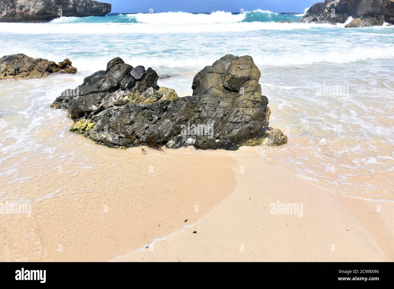 Formazione rocciosa su una spiaggia di Aruba circondata da un oceano. Foto Stock