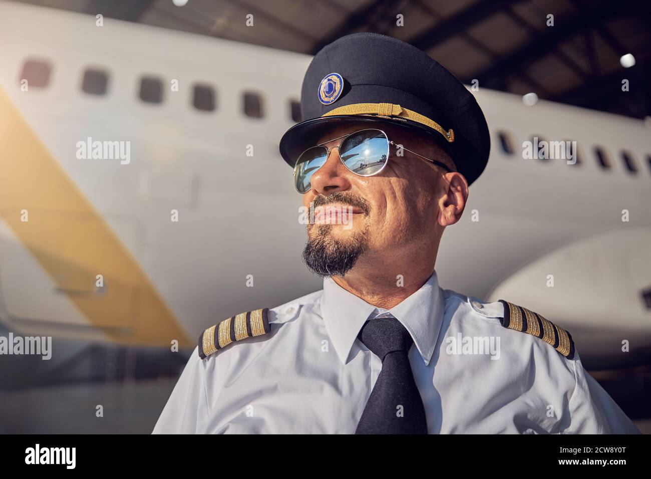 Bell'uomo bearded in cappello piloti guardando il sole cielo Foto Stock