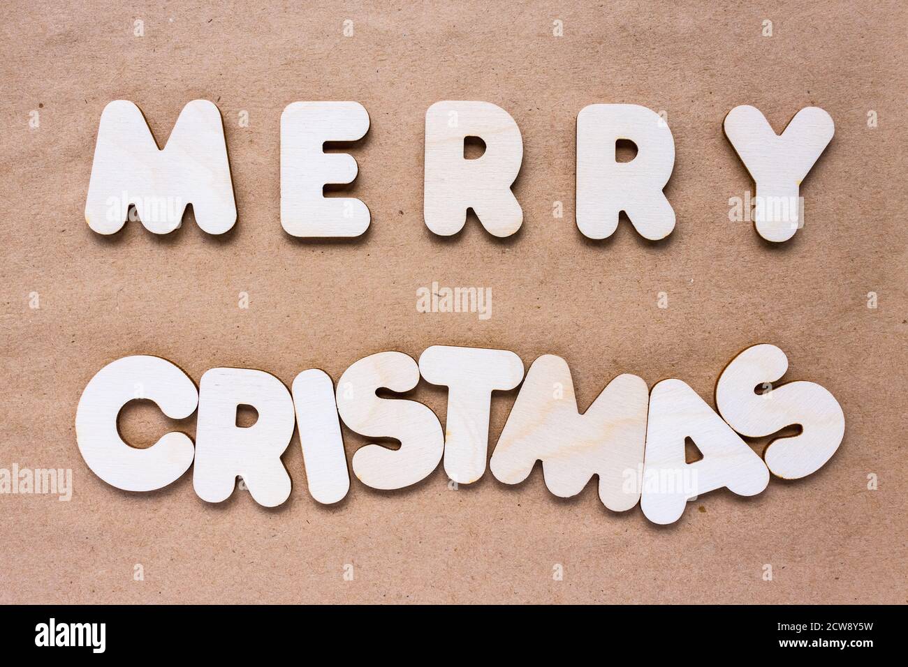 Allegro testo di Natale su carta artigianale sfondo fatto di legno alfabeto Foto Stock