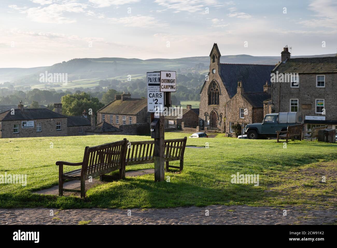 Reeth, Yorkshire Dales, Inghilterra in una mattinata autunnale - panchine verdi e cartelli di parcheggio di fronte alla Chiesa evangelica Congregazionale di Reeth Foto Stock