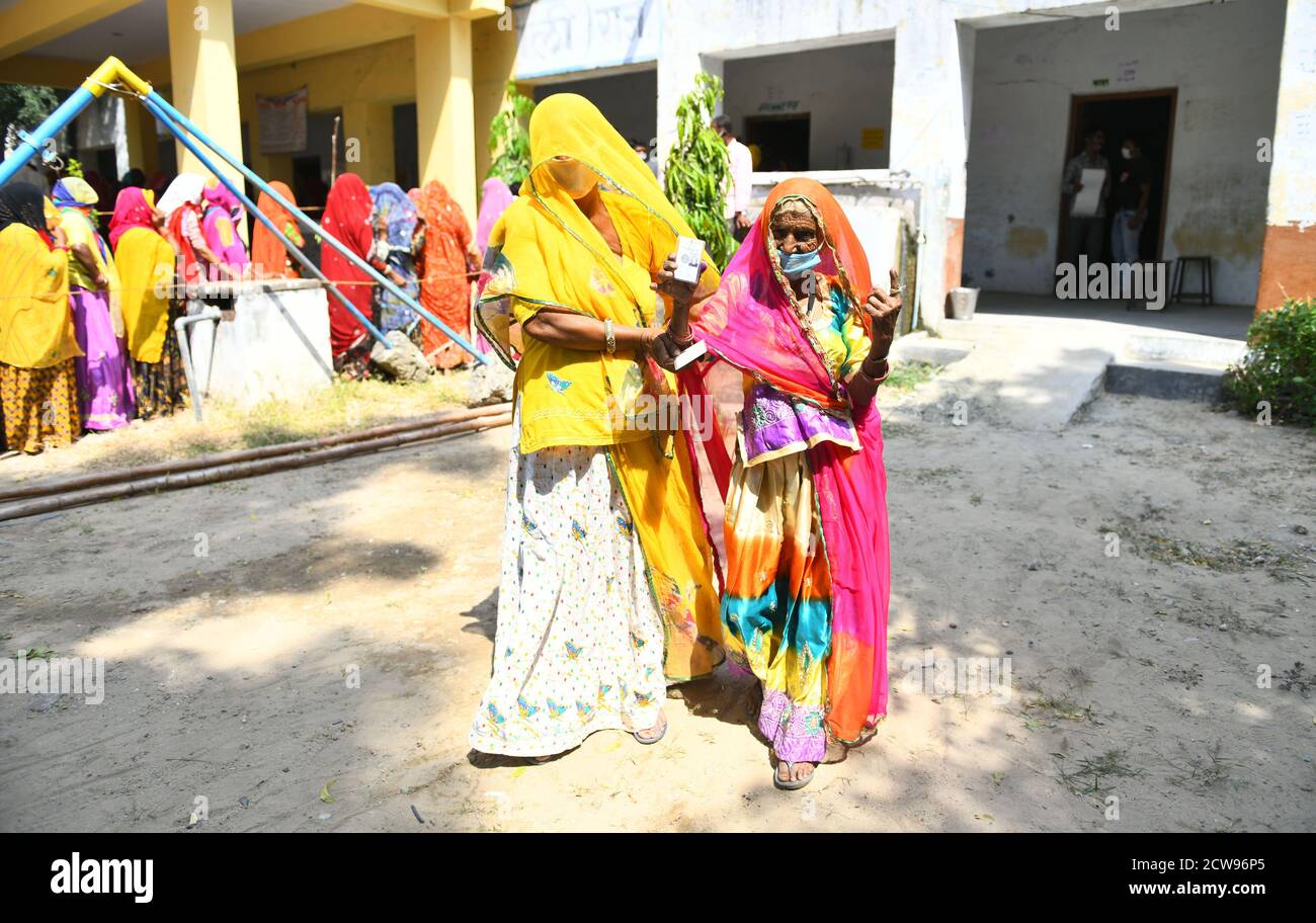 Beawar, Rajasthan, India, 28 settembre 2020: Un'anziana votatrice di donna Bardi Devi mostra il suo ID Voter e ha inked il dito dopo il voto del cast con la sua nuora durante le elezioni di Panchayati Raj, in mezzo alla pandemia di coronavirus in corso, nel villaggio di Sendra vicino a Beawar. Oltre il 83.50 per cento degli elettori del 31.95-lakh hanno espresso i loro voti nella prima fase di 947 grammi Panchayat (Consiglio del Villaggio) elezioni in 25 distretti in tutto lo stato. Le linee guida relative al COVID-19 non sono state seguite durante le elezioni. Gli elettori indossano maschere facciali ma non hanno mantenuto la distanza sociale. Credit: Sumit Saraswat/Alamy Live News Foto Stock