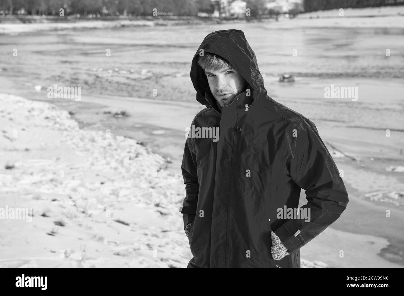 Uomo in rosso parka. inverno moda maschile. vestiti caldi per clima freddo. previsioni meteo. natura e uomo. man walking paesaggio innevato in sunset. viaggi e concetto di spedizione. Foto Stock