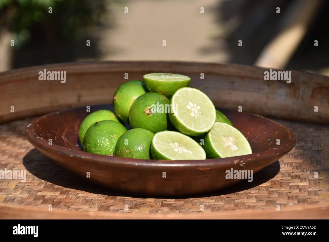 lime su un piatto di argilla, frutta per una bevanda rinfrescante Foto Stock