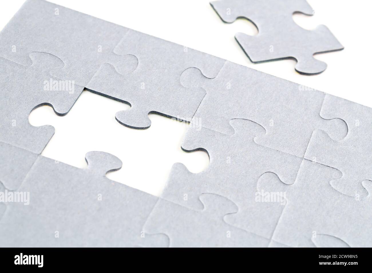 Pezzi di puzzle incompleti su sfondo bianco. Foto Stock