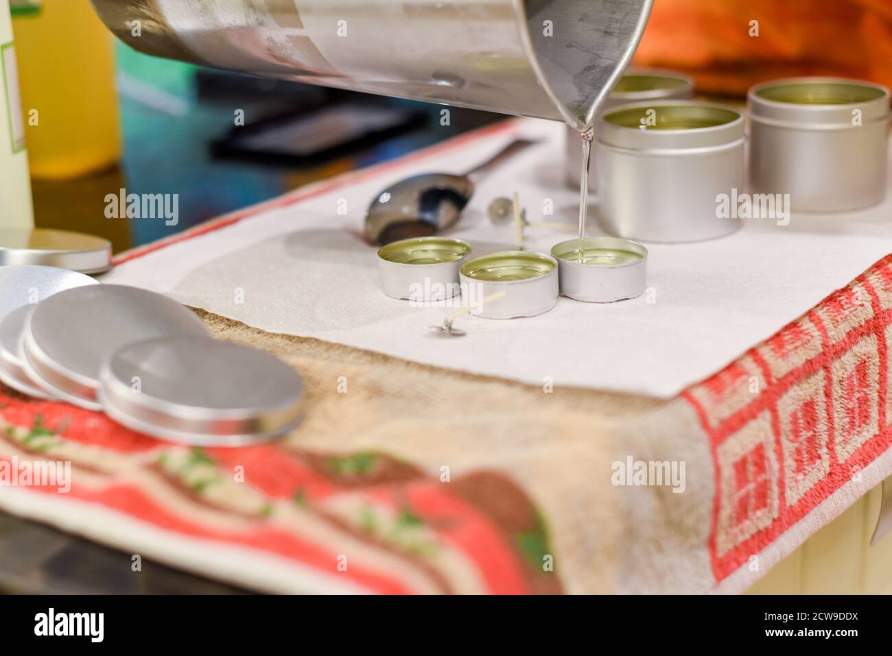 Occupazione creativa di fabbricazione della candela che mostra il versamento di liquido cera in vasi Foto Stock