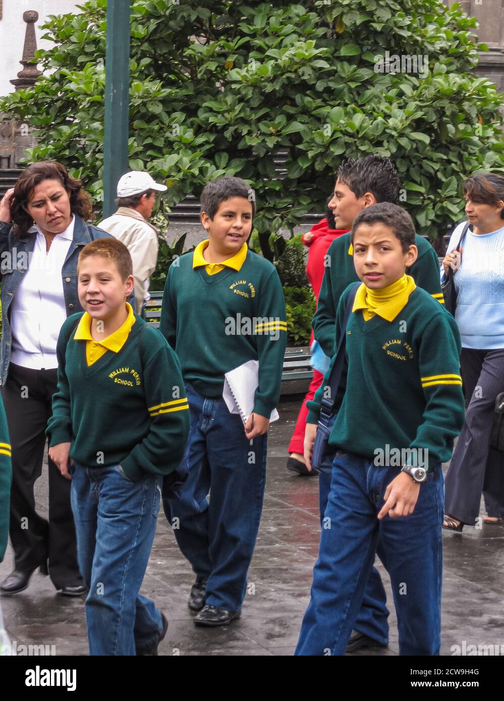 Quito, Ecuador - 2 dicembre 2008: Gruppo di studenti secondari di William Perkin International School che camminano con l'insegnante. Verde fogliame nella parte posteriore. Foto Stock