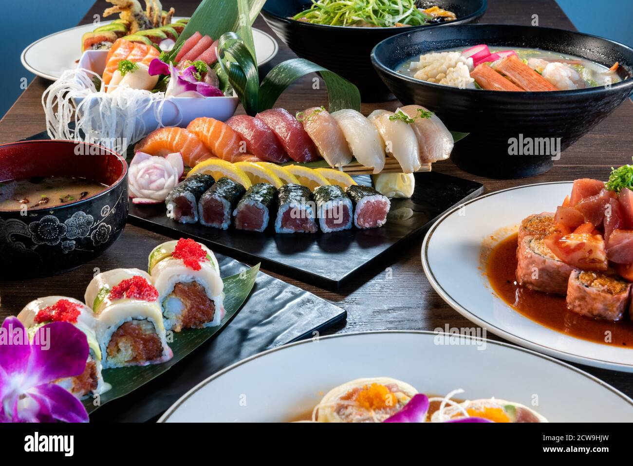 Enorme banchetto di pesce crudo, sushi e ciotole di ramen delizioso come la perfetta tavola giapponese si diffonde. Foto Stock