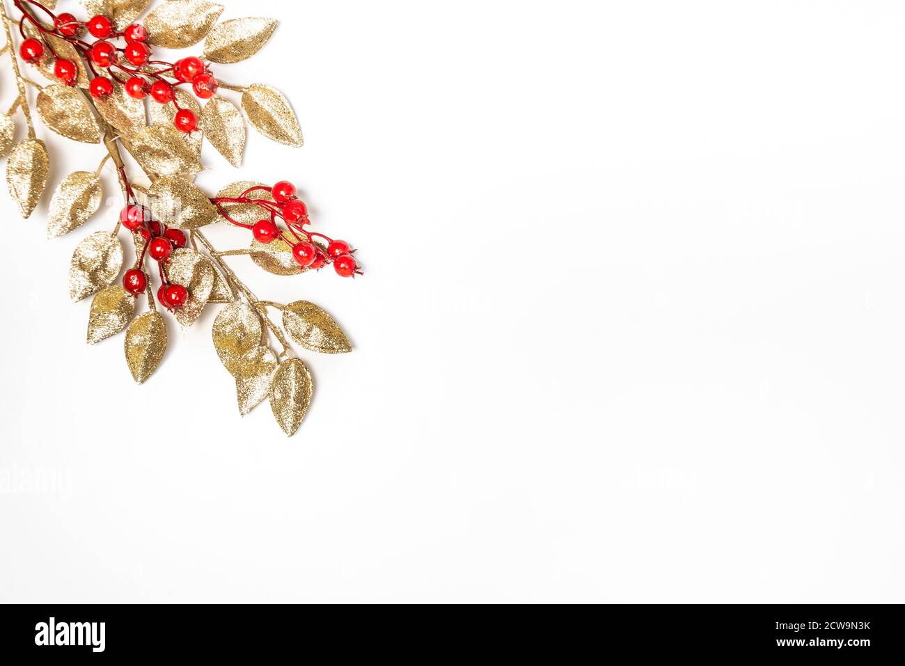 Foglia mistletoe d'oro su sfondo bianco. Tema di Natale. Spazio di copia. Foto Stock