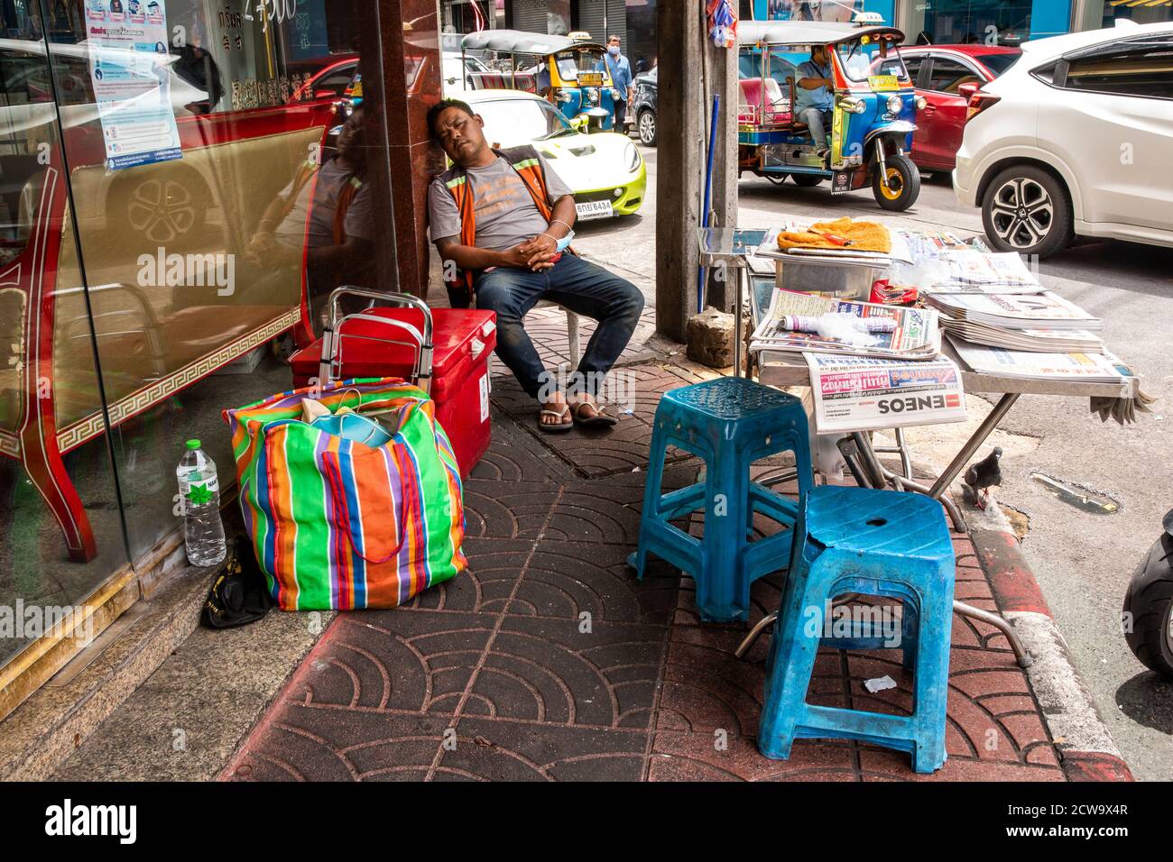 L'uomo prende un pisolino durante il pomeriggio caldo nella Chinatown di Bangkok. Foto Stock