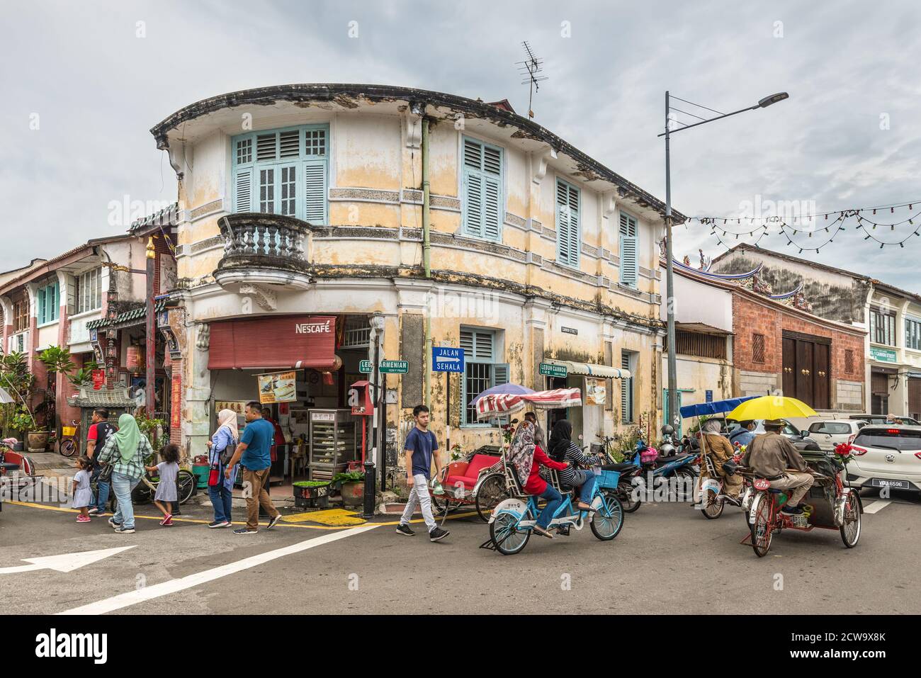 George Town, Penang, Malesia - 1 dicembre 2019: Vita di strada con classico risciò locale a George Town, Penang, Malesia in tempo nuvoloso. Foto Stock