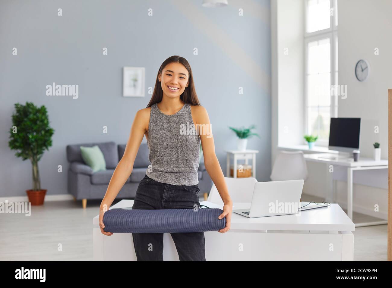 Felice giovane lavoratrice d'ufficio che prende la pausa dal lavoro per esercizio di yoga Foto Stock