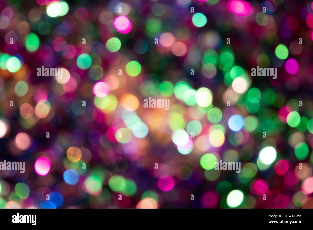 Festoso sfondo colorato bokeh con scintille psichedeliche colorate e puntini colorati come sfondo perfetto per silvester, celebrazione felice anno nuovo Foto Stock