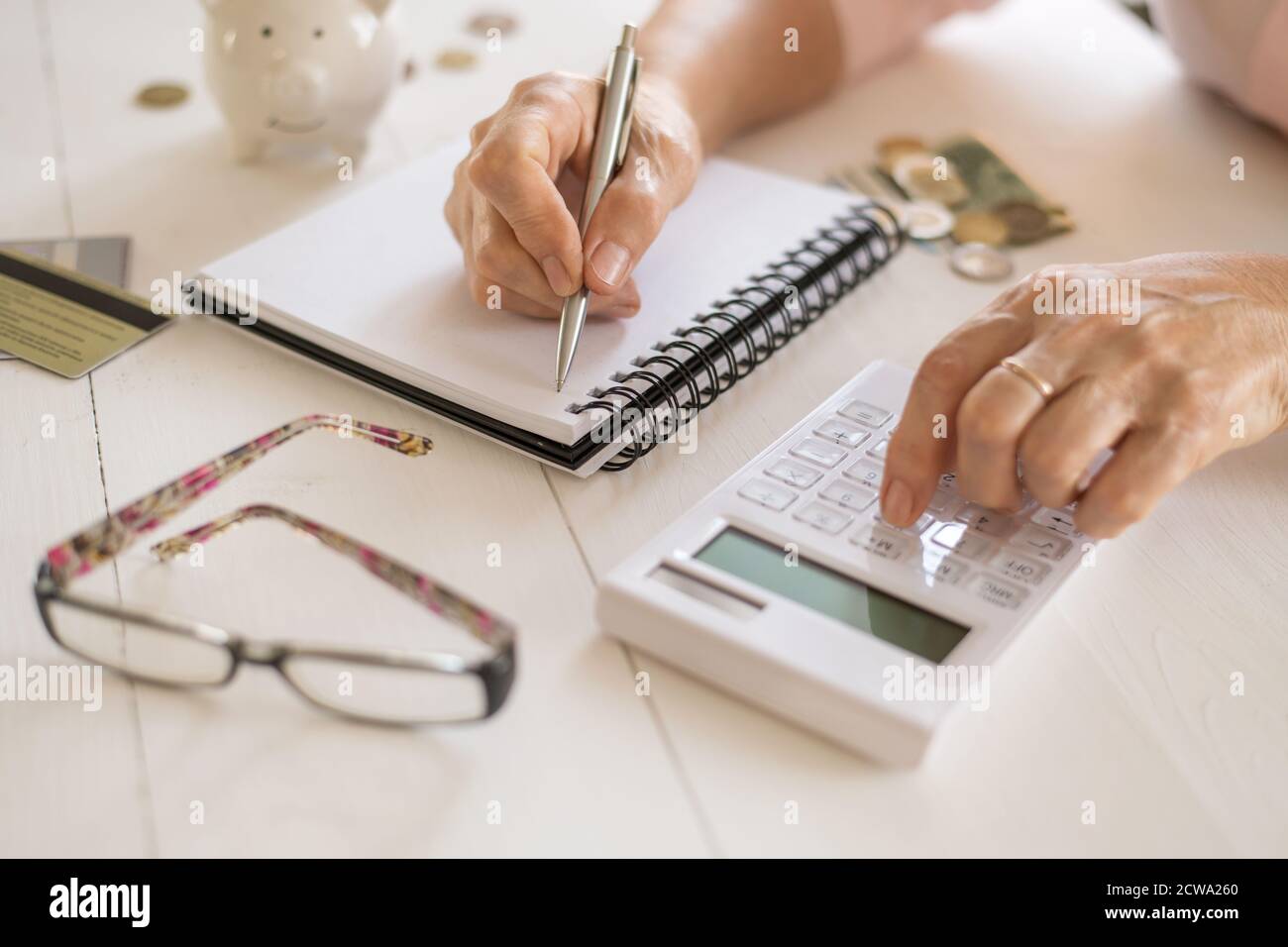 Le mani delle donne anziane contano le spese, progettano un preventivo il concetto di pensione, di risparmio, di vecchiaia. Foto Stock