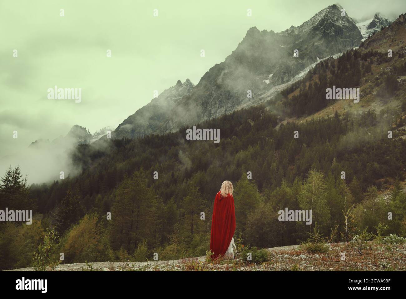 Donna sola guarda montagne desolate Foto Stock