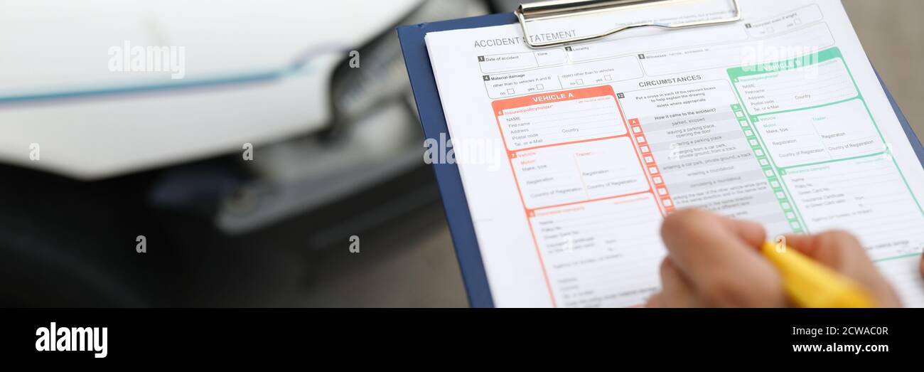 L'agente redige un evento assicurato dopo un incidente d'auto. Foto Stock