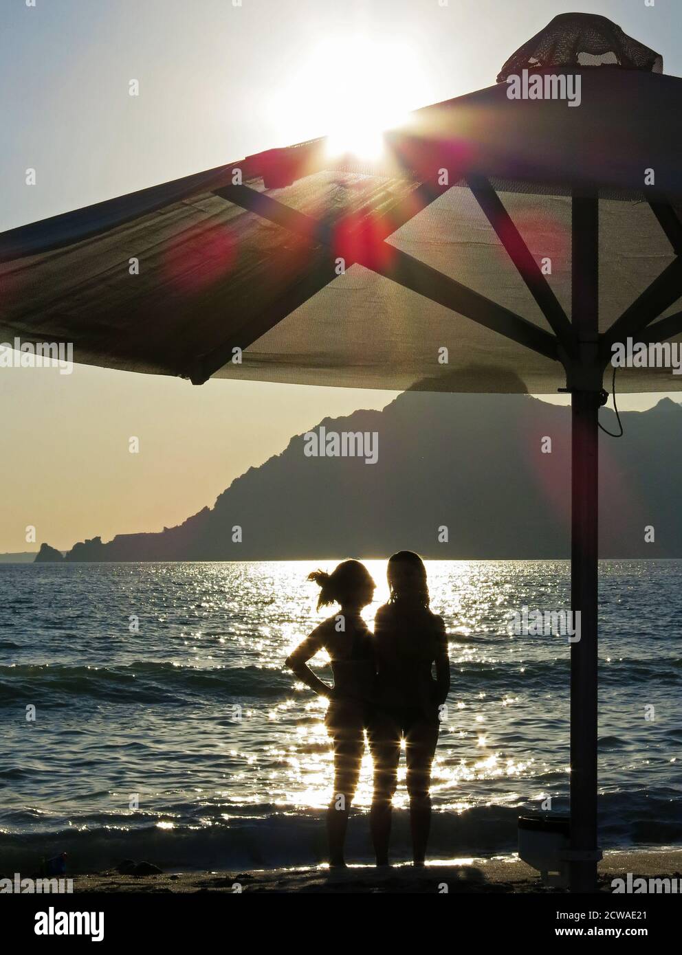 Sagome di due donne che chiacchierano in spiaggia. Concetto: Relax in spiaggia, vacanza. Foto Stock