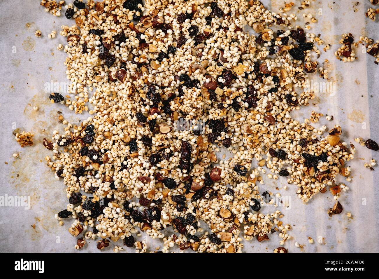 Granola di grano di miglio soffiato in casa con frutta secca e noci su carta da forno sfondo. Disposizione piatta, spazio. Colazione sana Foto Stock