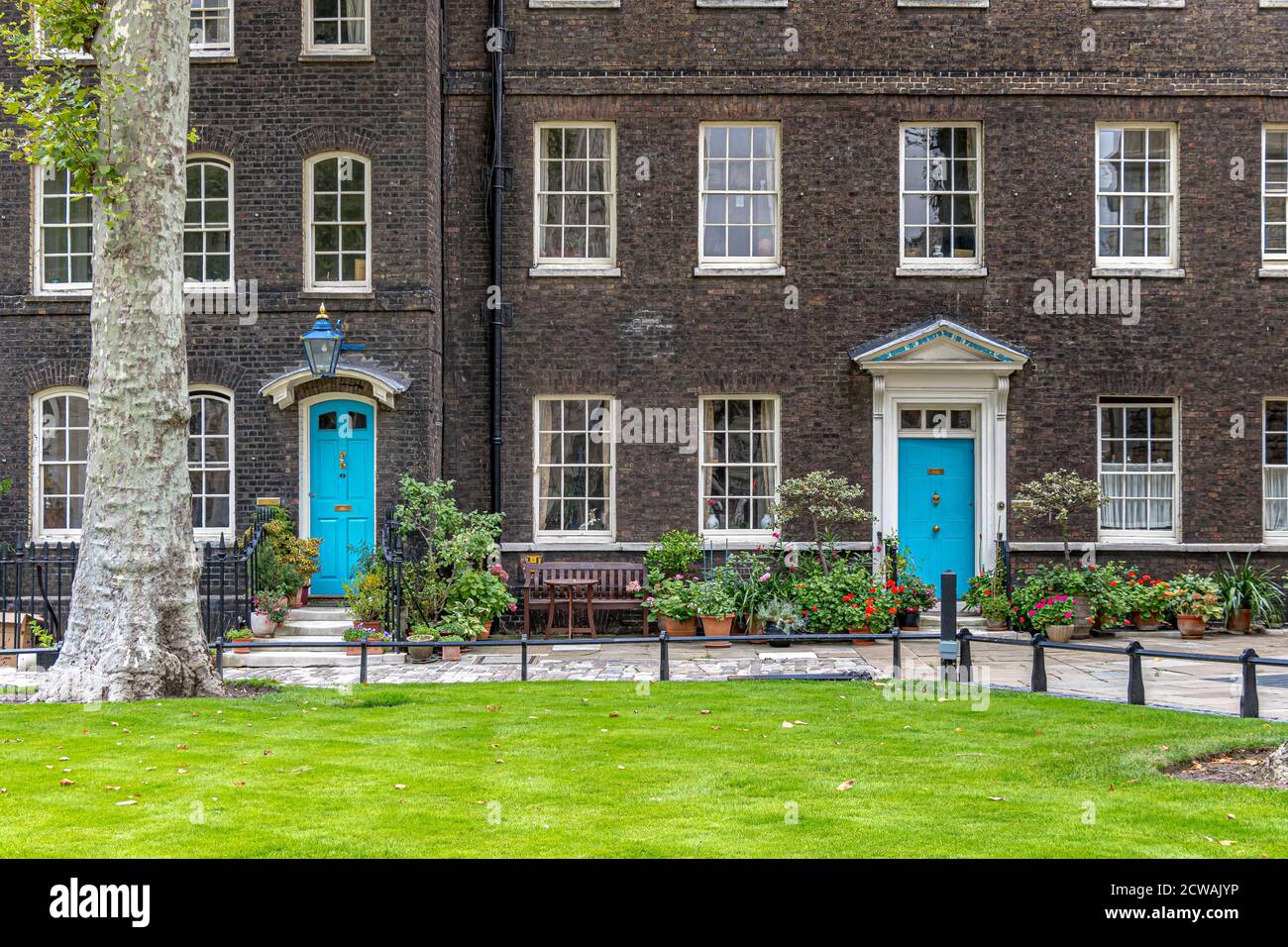 Eleganti case con porte blu di fronte a Tower Green , all'interno della Torre di Londra , Londra EC3 Foto Stock