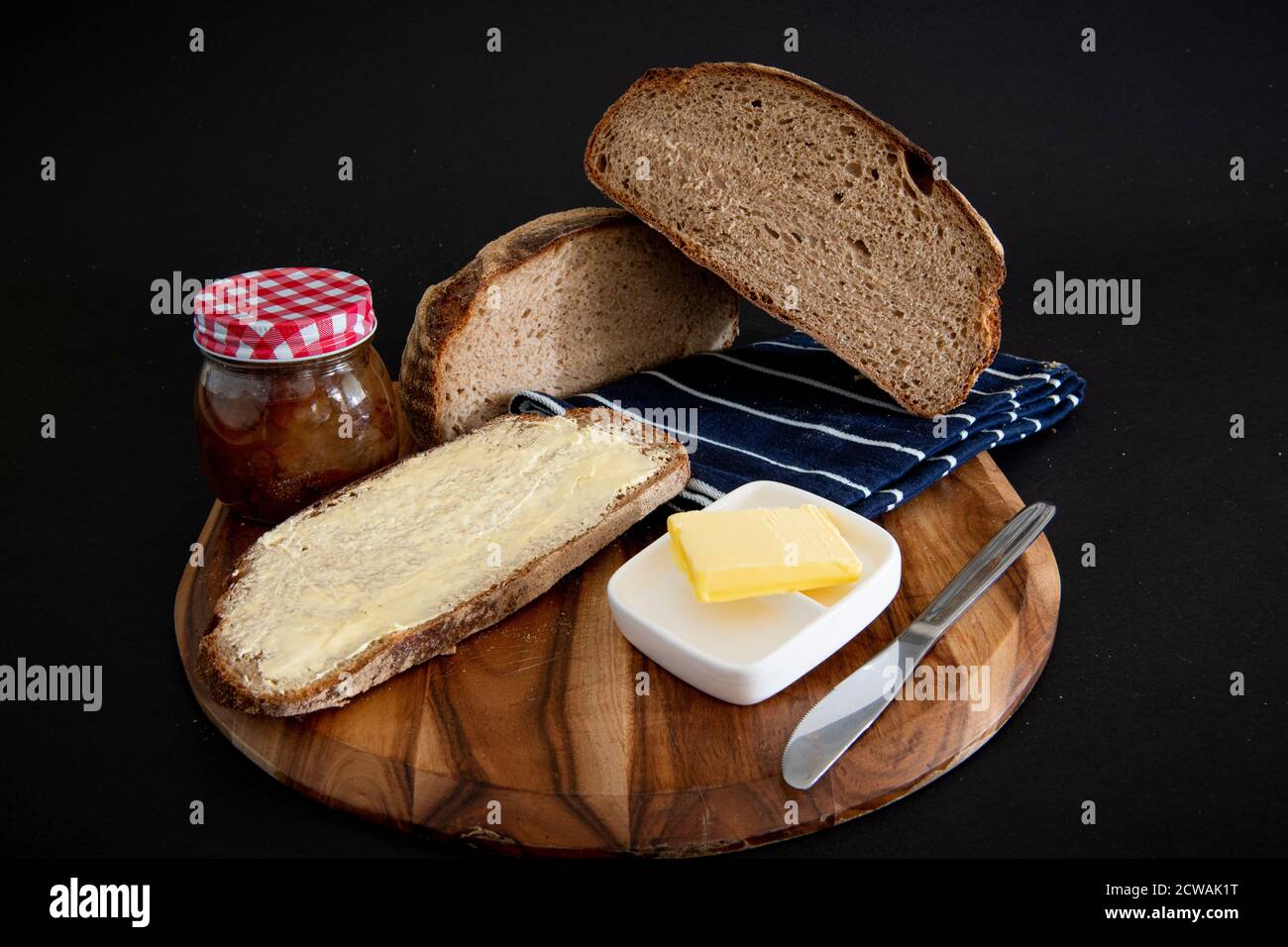 Pane di segale su una tavola di legno con fondo nero Foto Stock