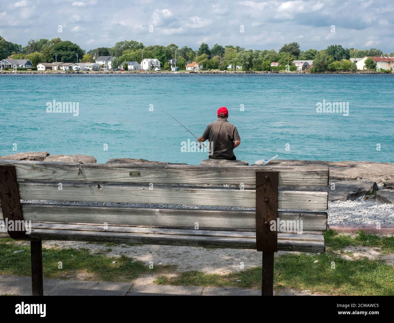 Sport dell'uomo pesca sul fiume Sarnia di St Clair Ontario Canada Port Huron Michigan USA si trova sul fiume far Banca Foto Stock