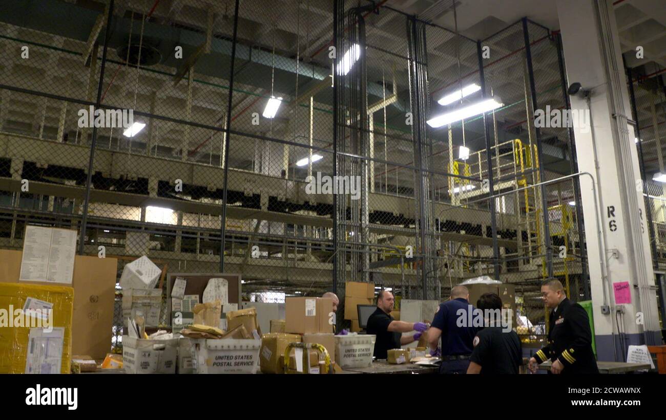 Gli investigatori della FDA presso la JFK International mail Facility esaminano i pacchetti per aiutare a intercettare le droghe illecite. Le spedizioni di vettori privati richiedono dati elettronici per il targeting Customs and Border Protection (CBP), ma i servizi postali esteri non hanno questo requisito. Foto Stock