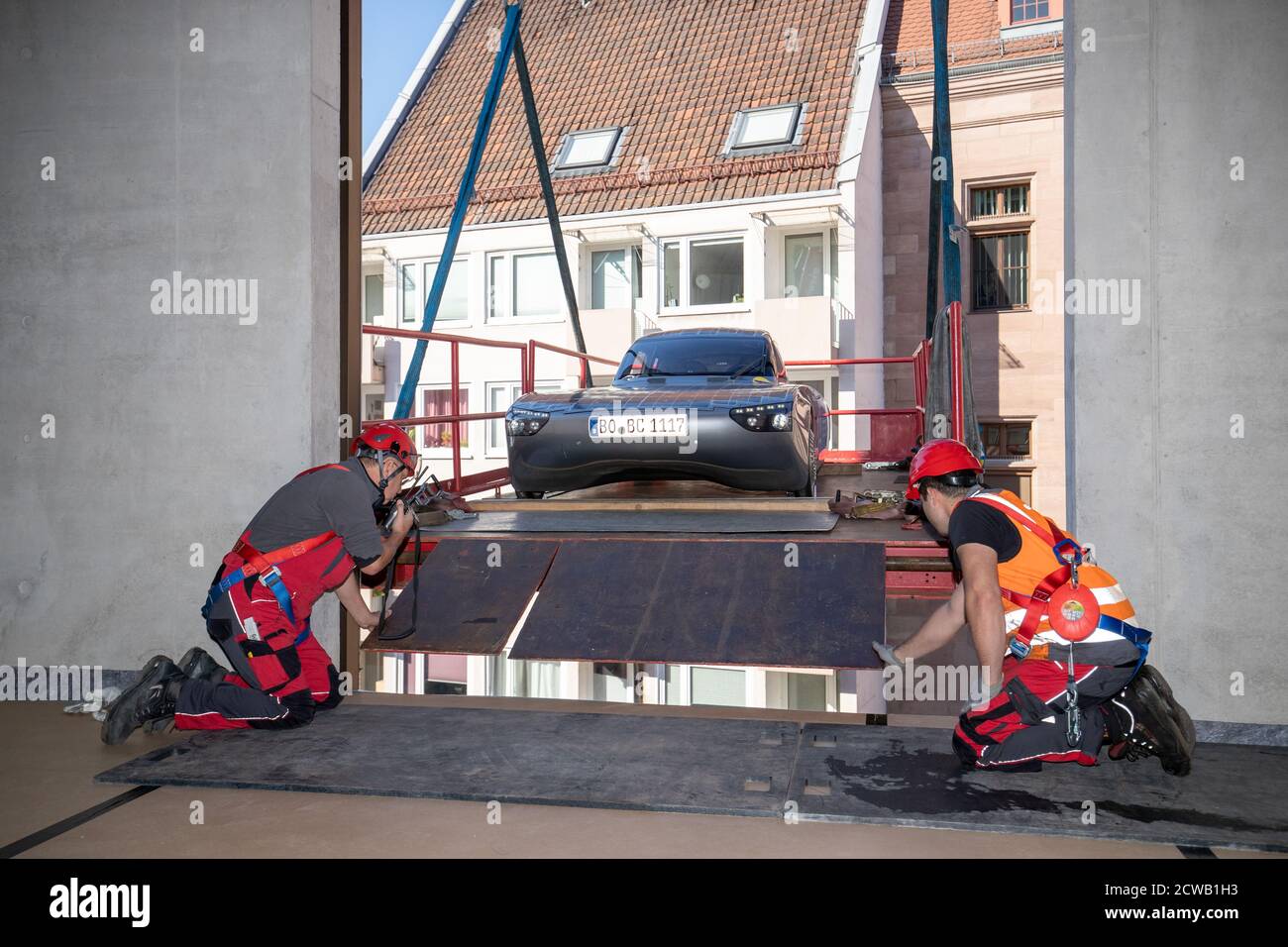 Norimberga, Germania. 29 Settembre 2020. L'auto solare blue.Cruiser è sollevato da una gru attraverso una finestra nel futuro Museo. Le prime quattro mostre si sono trasferite nello spazio espositivo della filiale del Deutsches Museum, che copre quasi 3000 metri quadrati, il 29 settembre. Una gru doveva sollevare gli oggetti attraverso una finestra nel museo perché erano troppo grandi per l'ascensore merci. Credit: Daniel Karmann/dpa/Alamy Live News Foto Stock