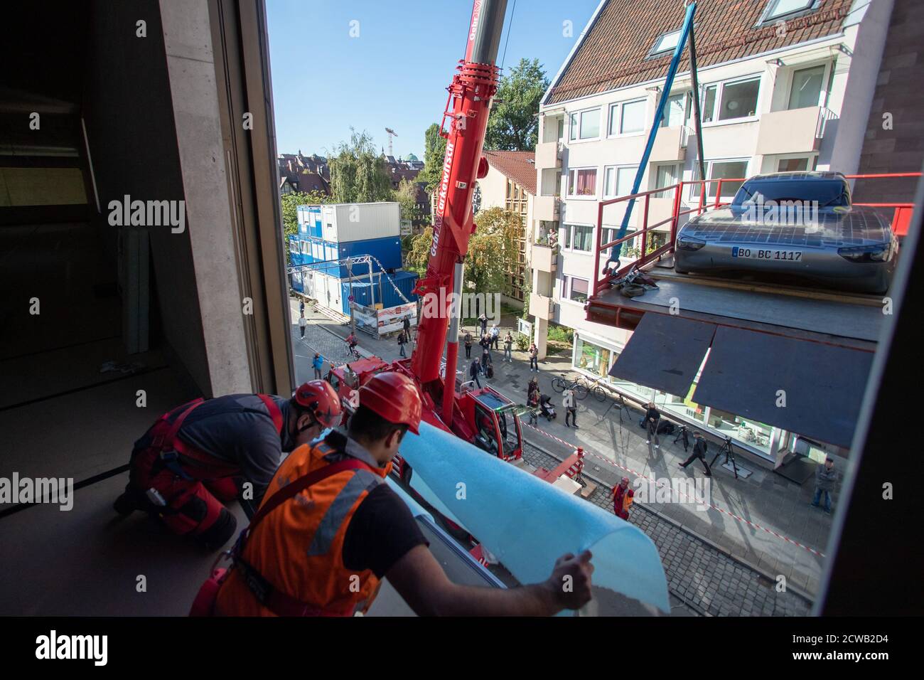 Norimberga, Germania. 29 Settembre 2020. L'auto solare blue.Cruiser è sollevato da una gru attraverso una finestra nel futuro Museo. Le prime quattro mostre si sono trasferite nello spazio espositivo della filiale del Deutsches Museum, che copre quasi 3000 metri quadrati, il 29 settembre. Una gru doveva sollevare gli oggetti attraverso una finestra nel museo perché erano troppo grandi per l'ascensore merci. Credit: Daniel Karmann/dpa/Alamy Live News Foto Stock