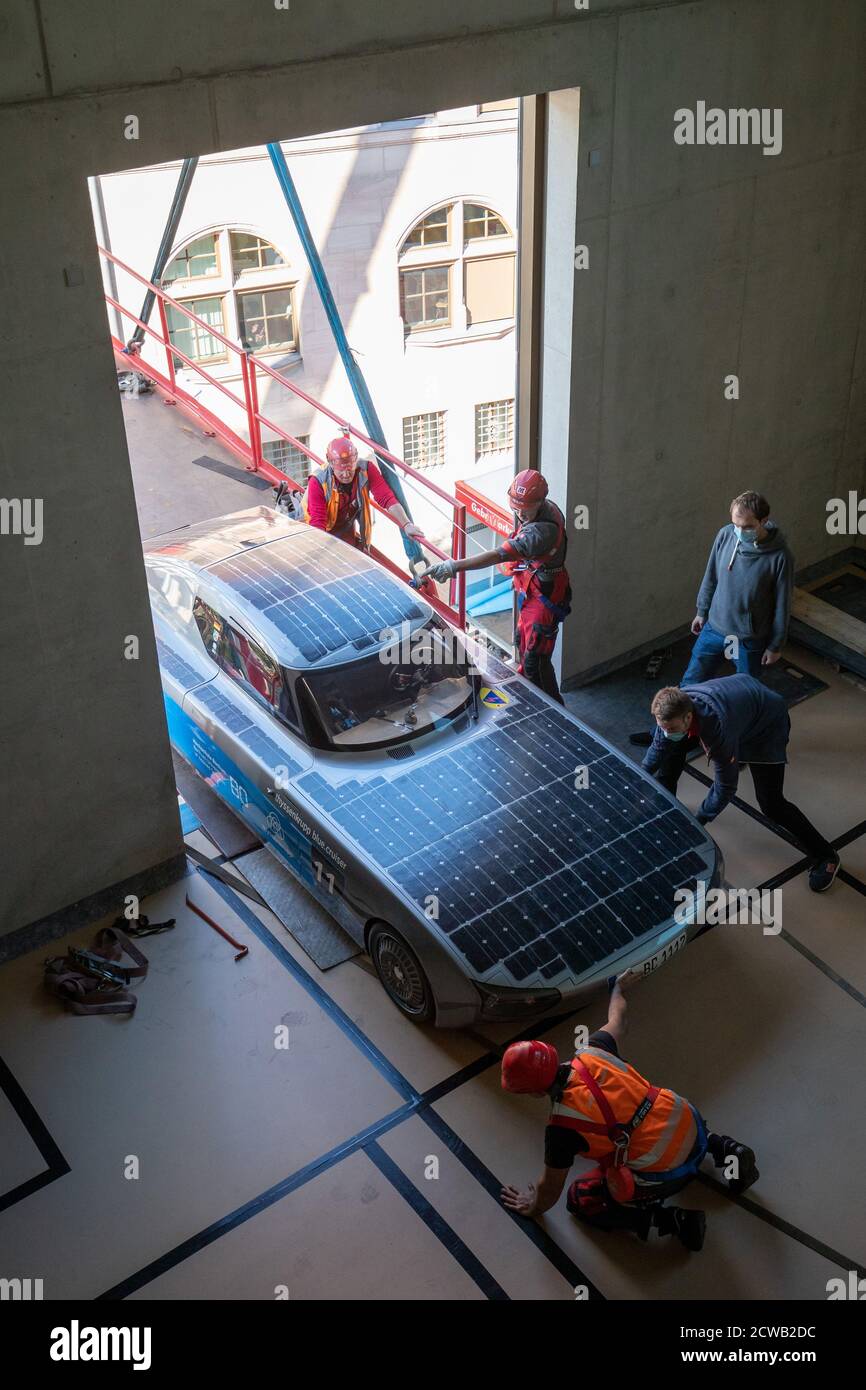 Norimberga, Germania. 29 Settembre 2020. L'auto solare blue.Cruiser è sollevato da una gru attraverso una finestra nel futuro Museo. Le prime quattro mostre si sono trasferite nello spazio espositivo della filiale del Deutsches Museum, che copre quasi 3000 metri quadrati, il 29 settembre. Una gru doveva sollevare gli oggetti attraverso una finestra nel museo perché erano troppo grandi per l'ascensore merci. Credit: Daniel Karmann/dpa/Alamy Live News Foto Stock