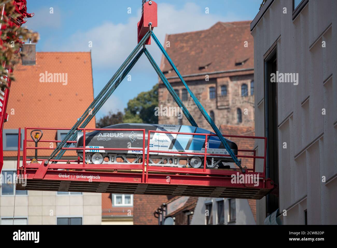 Norimberga, Germania. 29 Settembre 2020. Un prototipo per il progetto Hyperloop, in cui treni magneticamente guidati devono trasportare persone in un tubo a vuoto, è sollevato da una gru attraverso una finestra nel Museo del futuro. Le prime quattro mostre si sono trasferite nello spazio espositivo della filiale del Deutsches Museum, che copre quasi 3000 metri quadrati, il 29 settembre. Una gru doveva sollevare gli oggetti attraverso una finestra nel museo perché erano troppo grandi per l'ascensore merci. Credit: Daniel Karmann/dpa/Alamy Live News Foto Stock