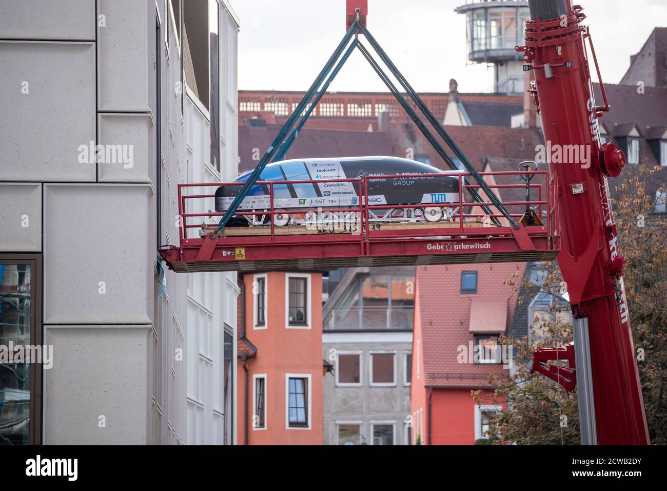 Norimberga, Germania. 29 Settembre 2020. Un prototipo per il progetto Hyperloop, in cui treni magneticamente guidati devono trasportare persone in un tubo a vuoto, è sollevato da una gru attraverso una finestra nel Museo del futuro. Le prime quattro mostre si sono trasferite nello spazio espositivo della filiale del Deutsches Museum, che copre quasi 3000 metri quadrati, il 29 settembre. Una gru doveva sollevare gli oggetti attraverso una finestra nel museo perché erano troppo grandi per l'ascensore merci. Credit: Daniel Karmann/dpa/Alamy Live News Foto Stock