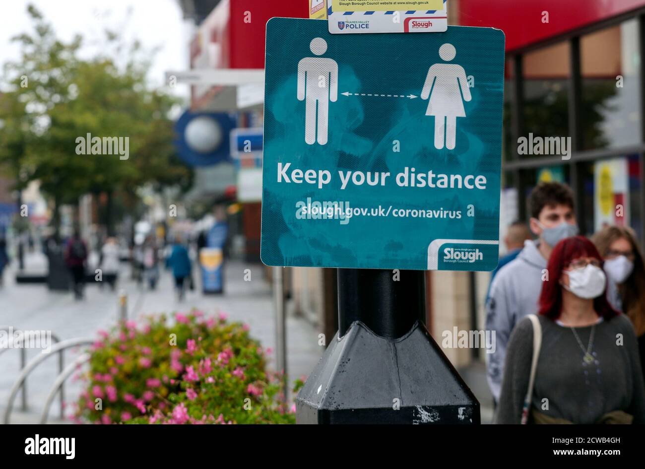Gli acquirenti di High Street a Slough come la città del Berkshire è stato rimandato alla lista di controllo del governo a causa di un aumento dei casi di coronavirus. Foto Stock