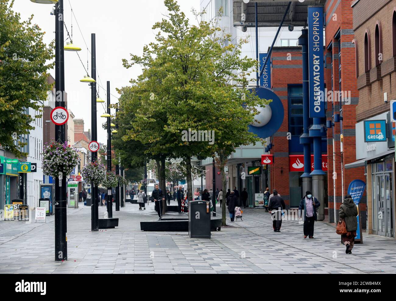 Gli acquirenti di High Street a Slough come la città del Berkshire è stato rimandato alla lista di controllo del governo a causa di un aumento dei casi di coronavirus. Foto Stock