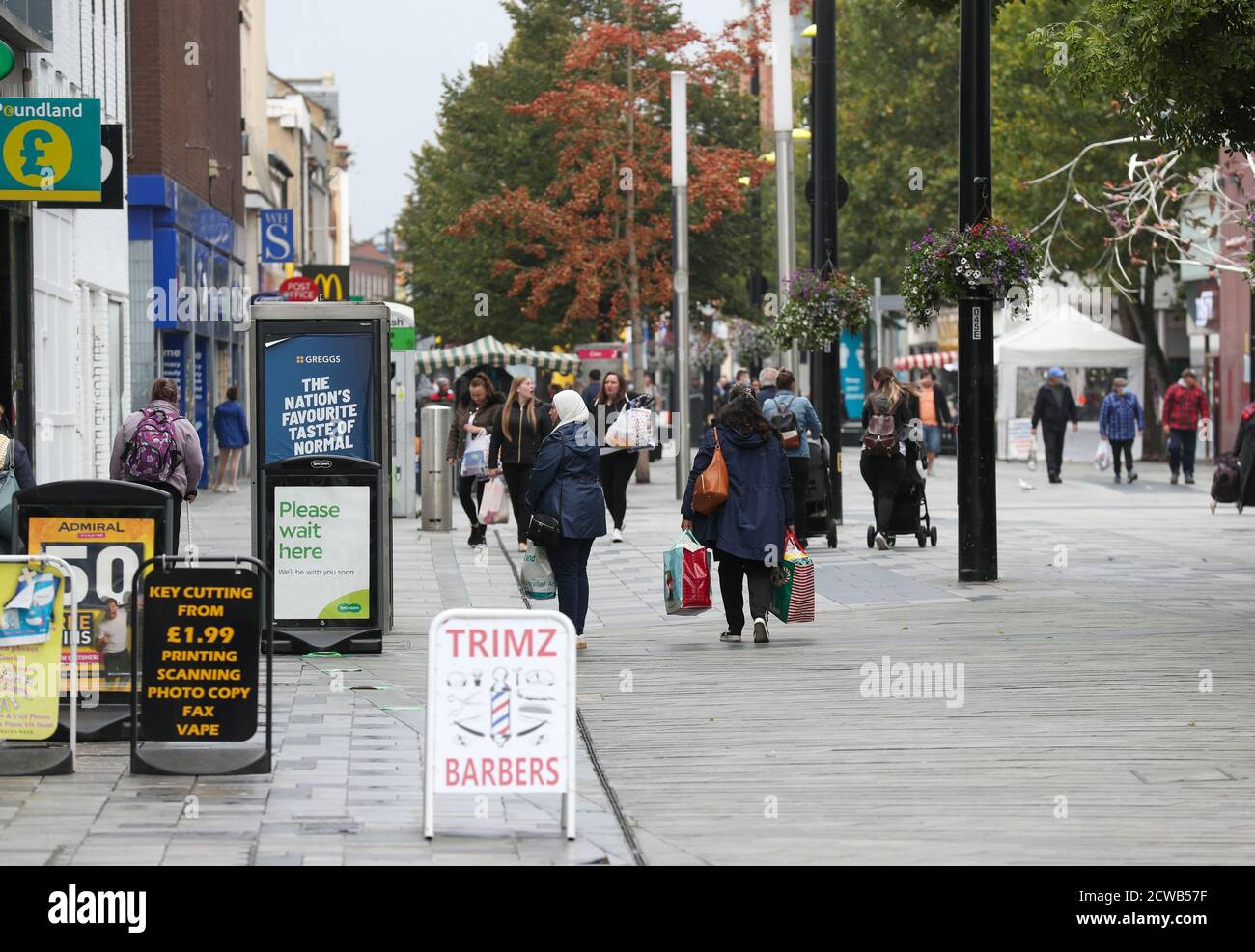 Gli acquirenti di High Street a Slough come la città del Berkshire è stato rimandato alla lista di controllo del governo a causa di un aumento dei casi di coronavirus. Foto Stock