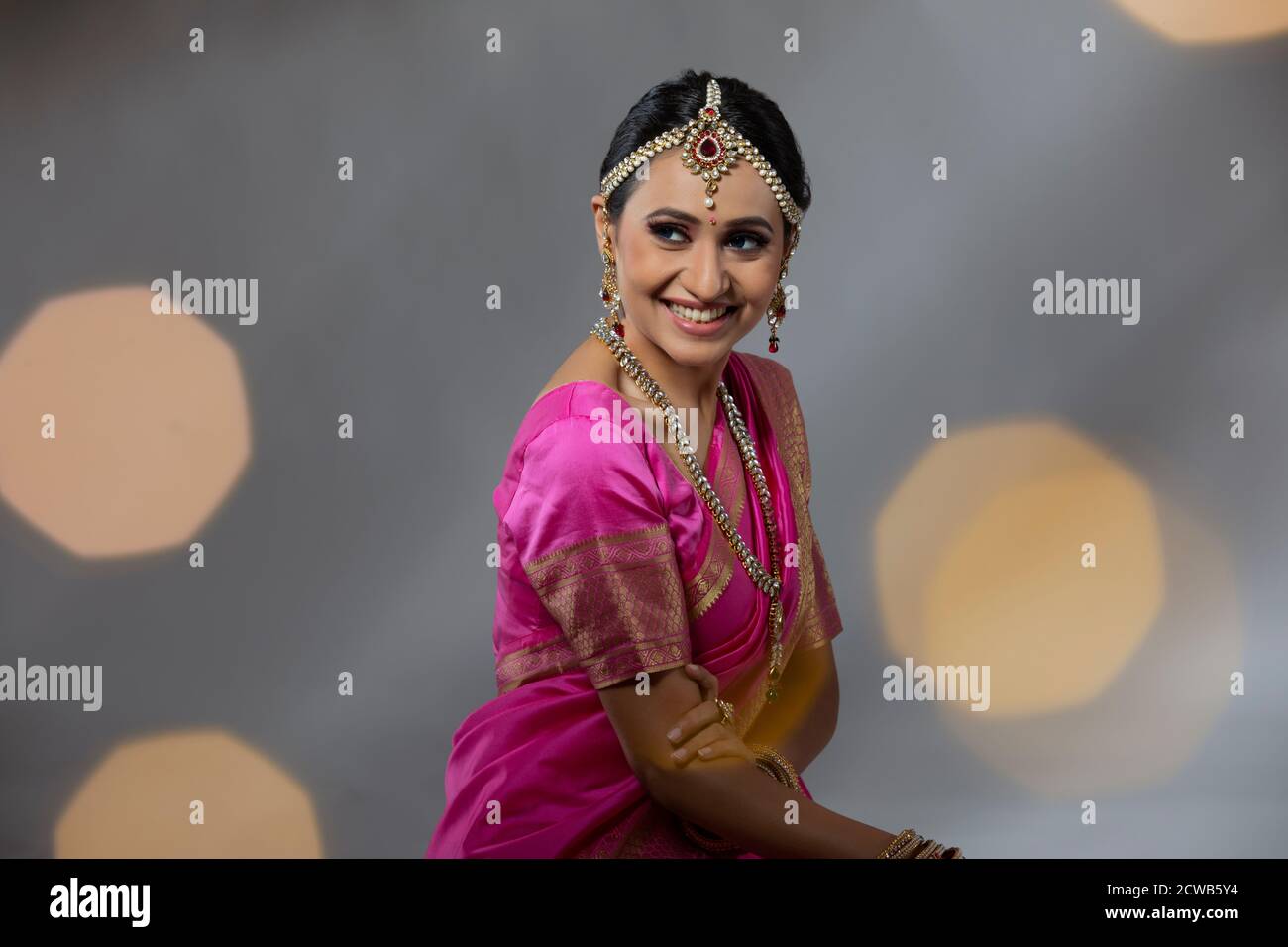Ritratto di una donna in una bella saree rosa sorridente Foto Stock