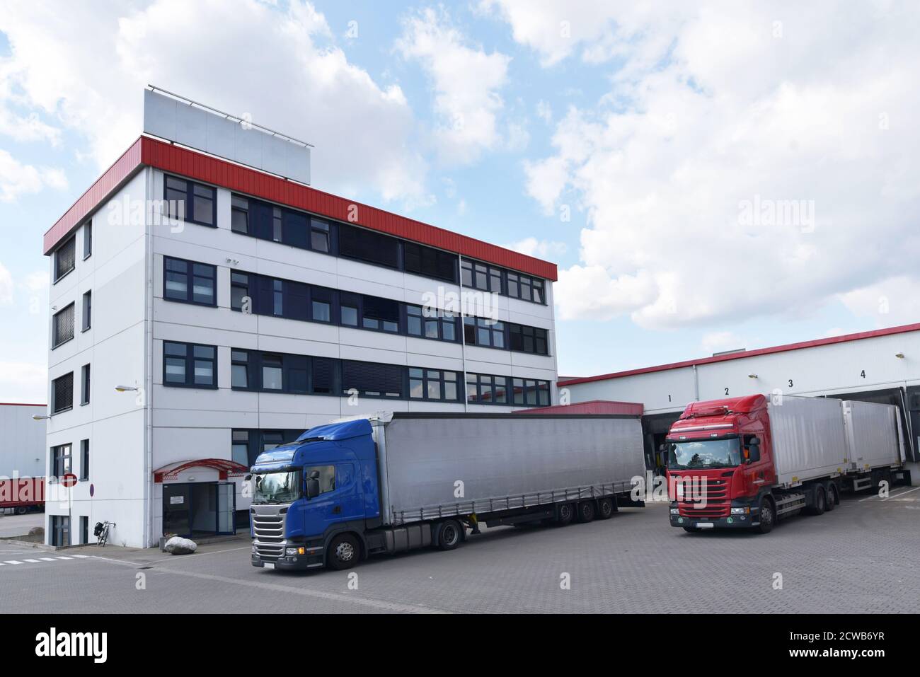 Camion che caricano ad un deposito di un'agenzia di spedizione - Trasporti e logistica nel commercio di merci Foto Stock