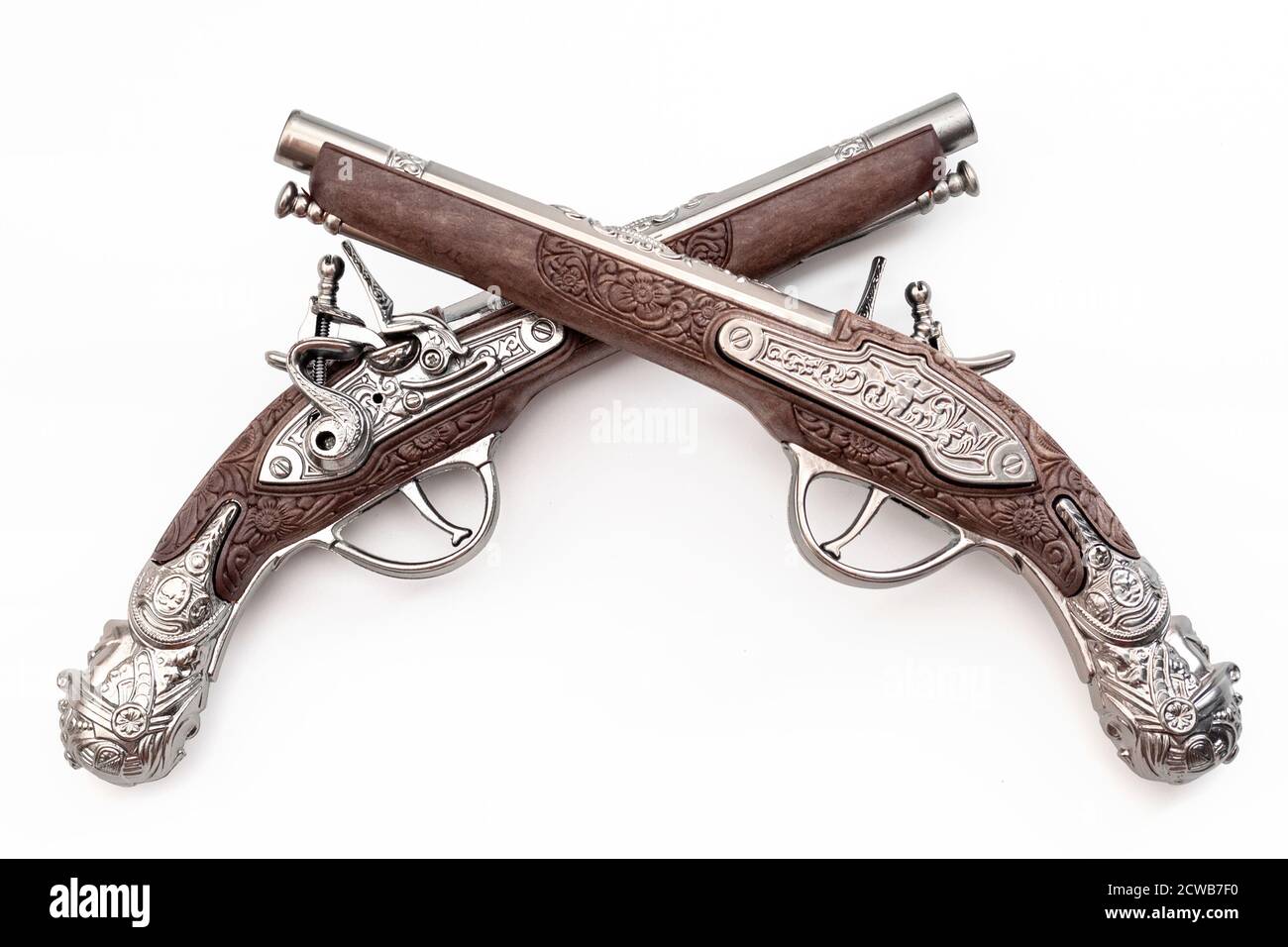 Armi da fuoco risalente alla rivoluzione americana e antico concetto di collezionismo con le pistole ornate in flintlock duellanti di vecchio stile incrociate nel duello isola Foto Stock