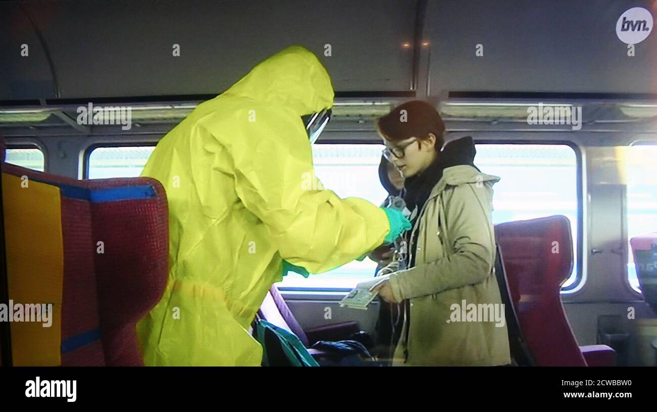 Controllo della temperatura di un passeggero su un treno belga durante la pandemia COVID-19. Marzo 2020. Foto Stock