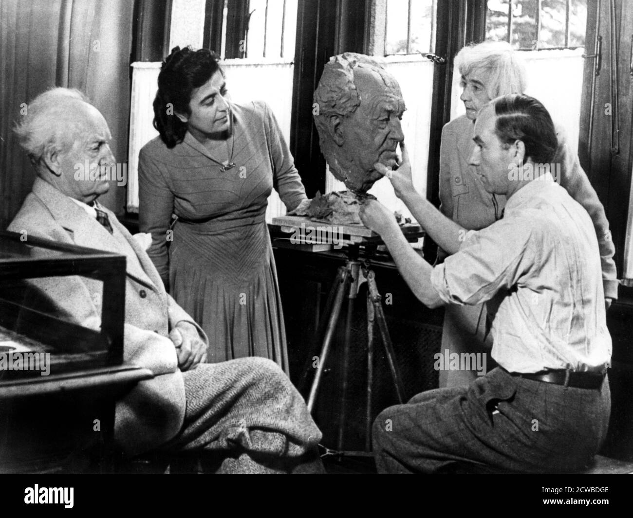 Arno Breker, scultore tedesco, al lavoro su un busto di Gerhart Hauptmann, 26 ottobre 1942. Breker's era popolare con molti nazisti principali e Hitler in particolare. Ha intrapreso numerose commissioni per il regime. Nel 1942 espone una mostra della sua opera a Parigi occupata. Hauptmann fu un drammaturgo tedesco che vinse il Premio Nobel per la letteratura nel 1912. Il fotografo è sconosciuto. Foto Stock