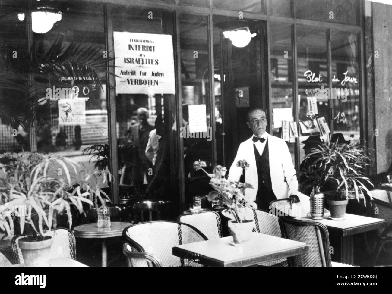 Avviso in una finestra del ristorante che vieta agli ebrei di entrare, Parigi occupata dai tedeschi, luglio 1940. La vita per gli ebrei francesi era oppressiva sotto l'occupazione nazista. I collaboratori della parte occupata del paese e della zona controllata dal regime di Vichy hanno cooperato con entusiasmo nella persecuzione. Il fotografo è sconosciuto. Foto Stock