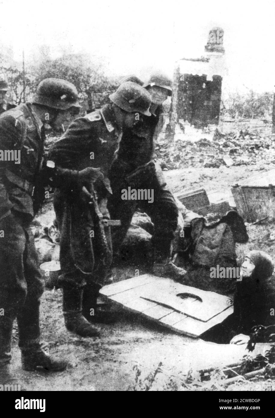 Truppe tedesche entranti a Stalingrado, Russia, settembre 1942. Una donna russa anziana emerge da una cantina nelle rovine frantumate della città. Combattuta tra l'agosto 1942 e il febbraio 1943, la battaglia di Stalingrado vide 750,000 soldati russi uccisi, feriti o catturati e oltre 40,000 civili persero la vita. Sul lato dell'asse, 740,000 sono stati uccisi o feriti e 110,000 sono stati detenuti. La sconfitta a Stalingrado fu un'inversione da cui la Germania nazista alla fine non fu in grado di riprendersi. Il fotografo è sconosciuto. Foto Stock