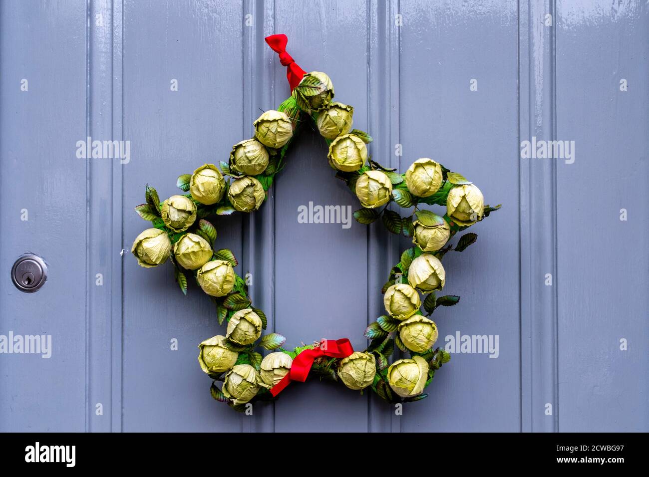 Una corona di Natale che si aggira su UNA porta, High Street, Lewes, East Sussex, UK. Foto Stock