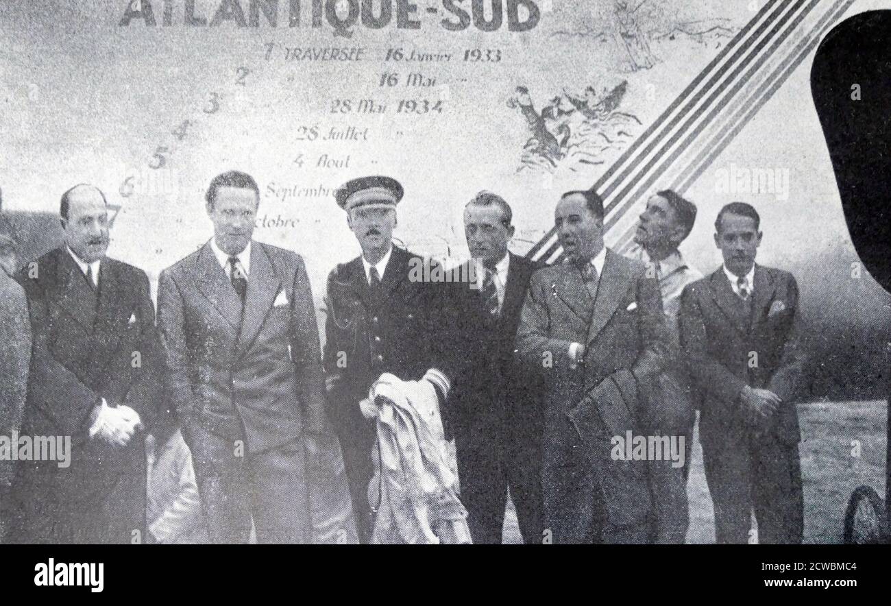 (3 da sinistra) Jean Mermoz (1901-1936), famoso aviatore francese, in uno dei suoi viaggi finali, di fronte all'aereo 'l'Arc-en-Ciel'. Foto Stock