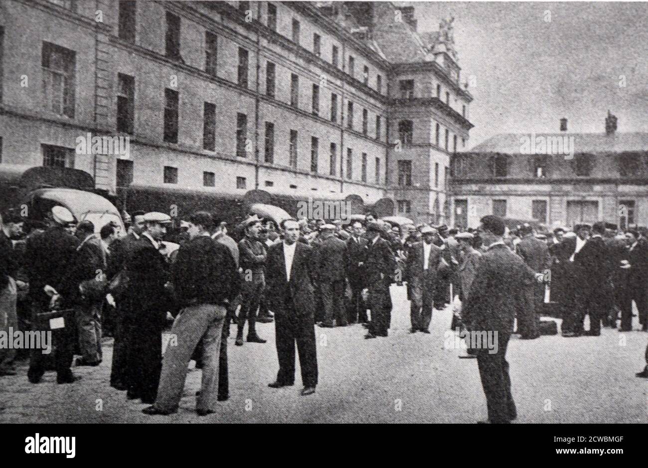 Foto in bianco e nero delle caserme militari nel cortile di Tour-Maubourg, Parigi, durante la prima ondata di mobilitazione delle forze armate francesi, settembre 1938. I reservisti e i civili stanno parlando per strada. Foto Stock