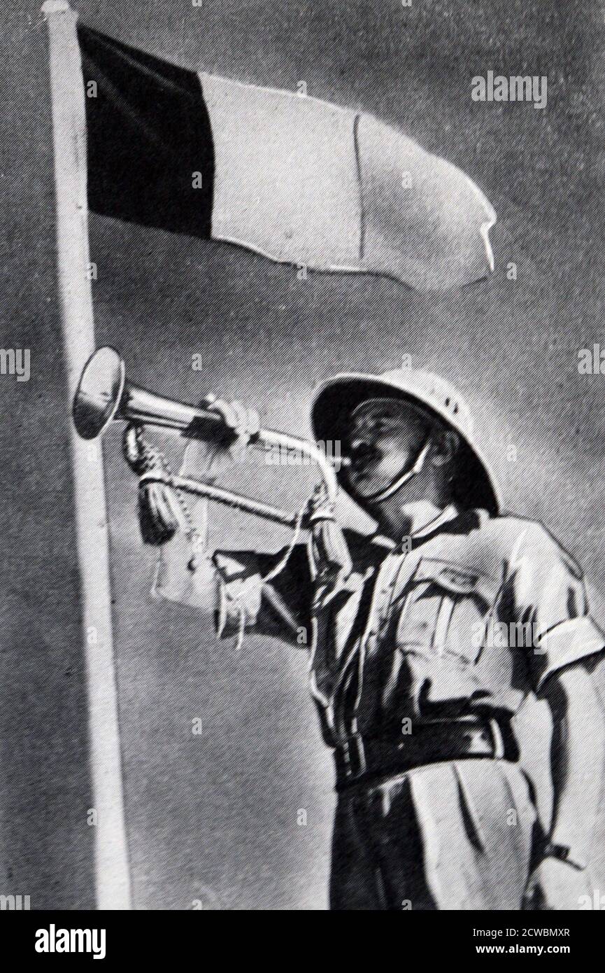 Fotografia in bianco e nero della seconda guerra mondiale (1939-1945); un soldato delle forze francesi libere in Siria soffia su una tromba con la bandiera francese che gli batte dietro su un flagpole. Foto Stock