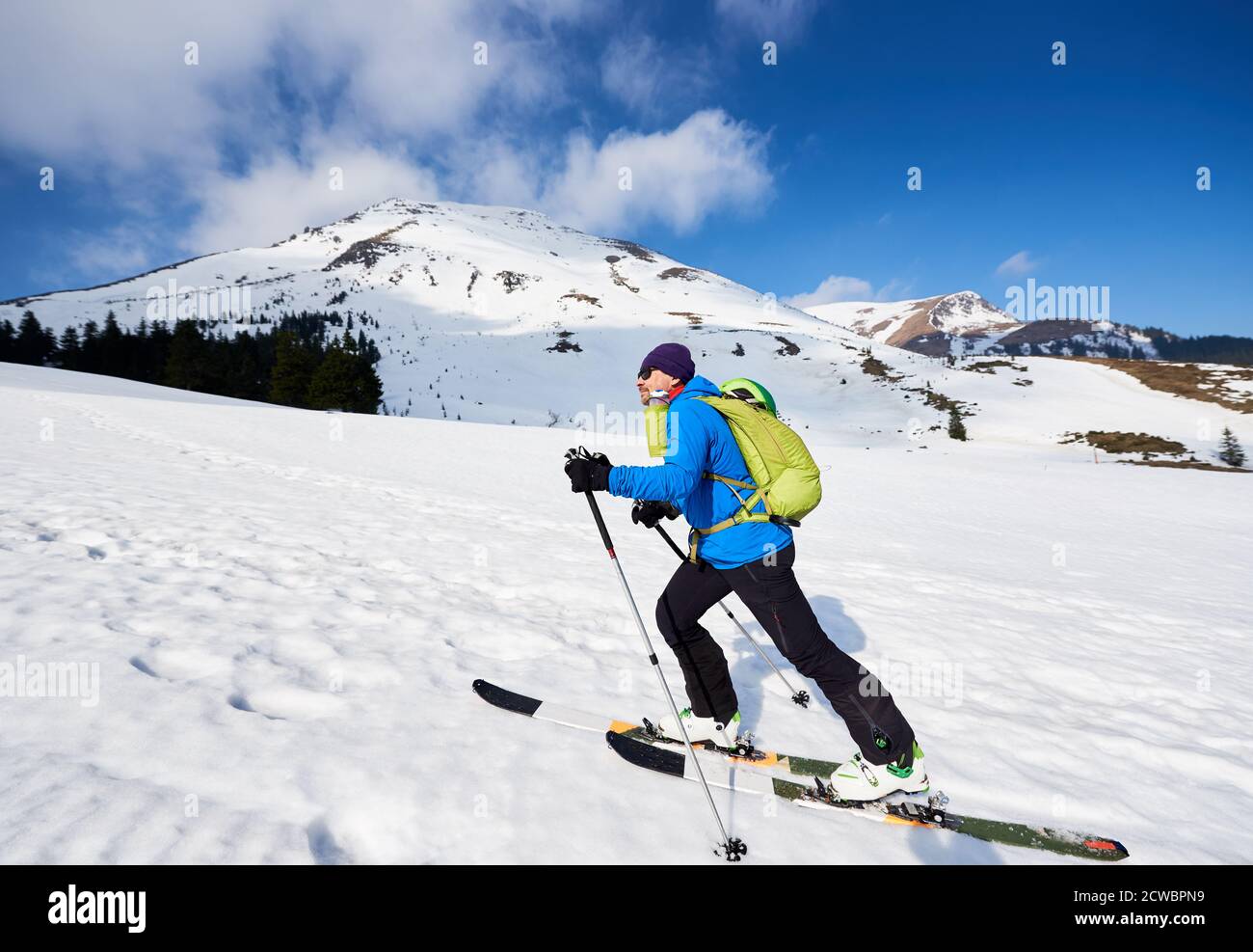 Scialpinismo uomo turistico ascendente durante lo sci alpinismo nelle montagne straordinariamente bianche. Neve e attività invernali, sciare in montagna. Foto Stock