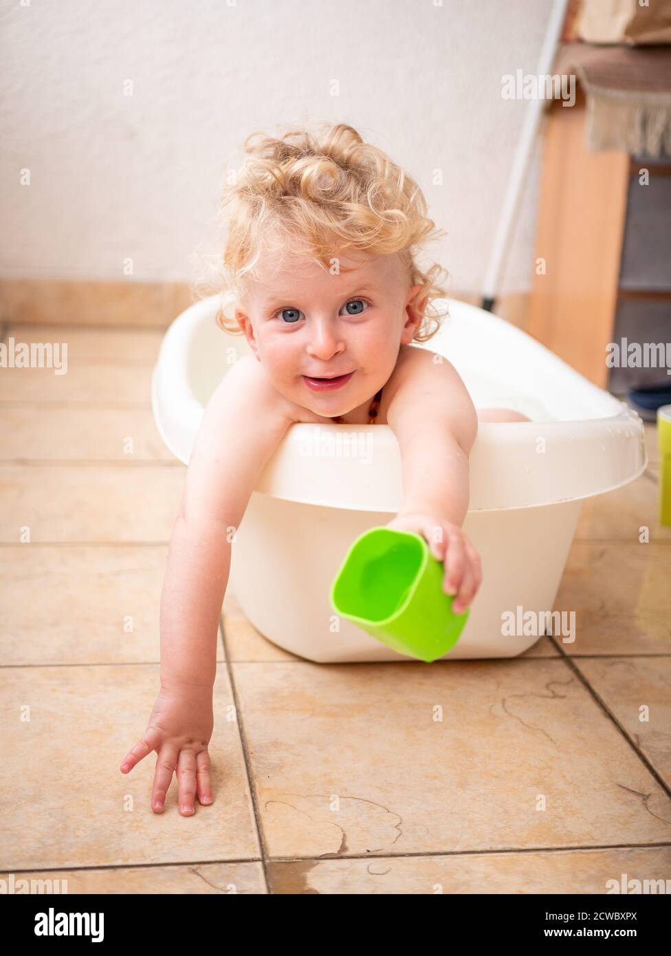Un bambino di un anno che si gode un bagno sul balcone Foto Stock